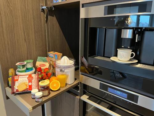 a counter with food and drinks on top of a microwave at Luxueus nieuw zonnig hoekappartement SEAVIEW Heldenplein - ruime garagebox - 2 fietsen in Knokke-Heist