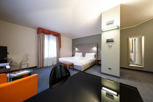 a hotel room with a bed and a desk at Settecento Hotel in Presezzo