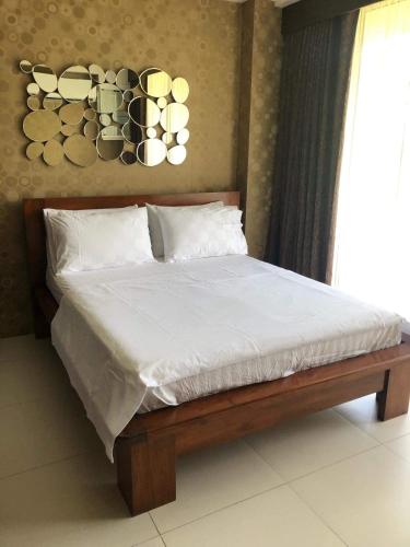a bed with white sheets and pillows in a bedroom at Bonel condo at Pico de Loro in Cutad