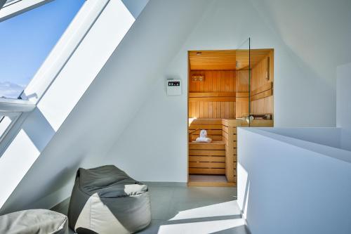 an attic room with a bed and a chair at Haus auf der Düne in Hörnum