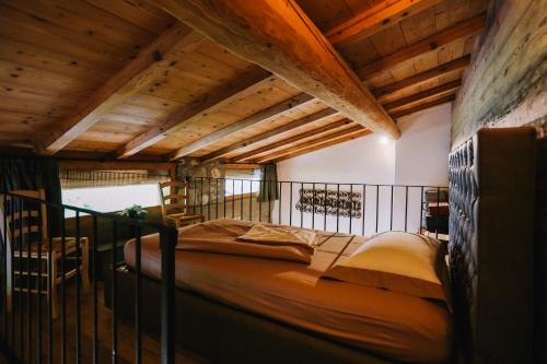 a bedroom with a bed in a room with wooden ceilings at AGRITURISMO CA' FENILE in Alzano Lombardo