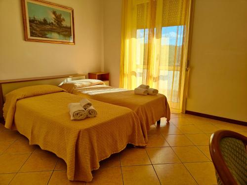 dwa łóżka z ręcznikami na nich w pokoju w obiekcie Lanterna Verde w mieście Torre Orsaia