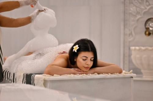a woman laying in a bath tub in a mirror at Ramada by Wyndham Sofia City Center in Sofia