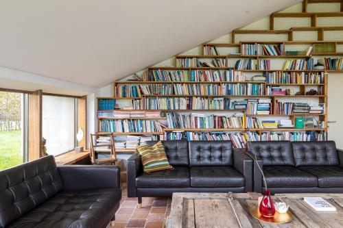 - un salon avec deux canapés et une grande étagère à livres dans l'établissement Het Verblijf, à Sint-Martens-Lennik