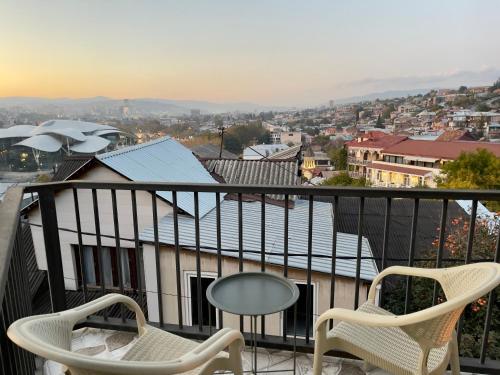 a balcony with two chairs and a table at Hotel Marioni in Tbilisi City