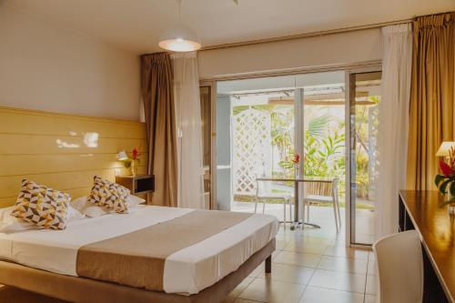 ein Hotelzimmer mit einem Bett und einem Balkon in der Unterkunft Résidence l'Archipel in Saint-Gilles-les-Bains