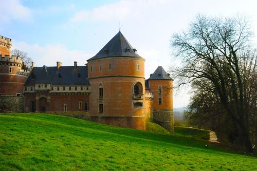 een kasteel bovenop een groene heuvel bij Het Verblijf in Sint-Martens-Lennik