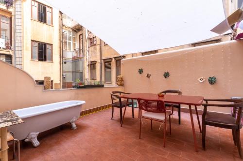 a balcony with a bath tub and a table and a table and chairs at Solemar Sicilia - Palazzo Pirrotta in Palermo