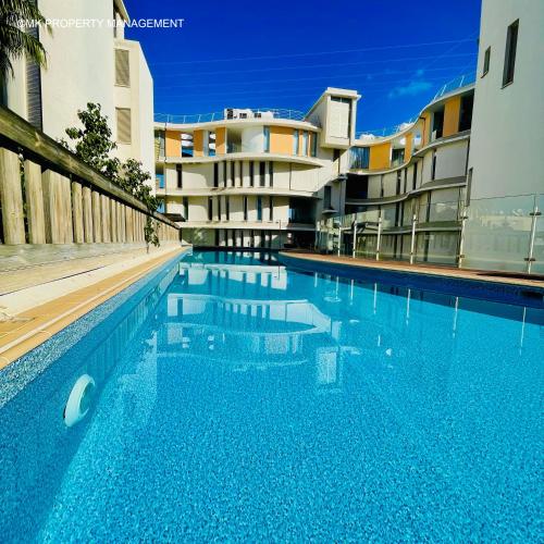 a swimming pool in front of a building at City Flats Apt.C307 in Larnaca