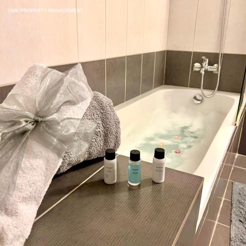 a bathroom with a bath tub with three bottles on the floor at City Flats Apt.C307 in Larnaca