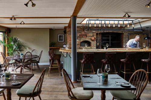 a man standing at a bar in a restaurant at Hotel Indigo - Stratford Upon Avon by IHG in Stratford-upon-Avon
