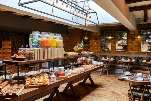 a bakery with a bunch of pastries on display at Hotel Indigo - Stratford Upon Avon by IHG in Stratford-upon-Avon