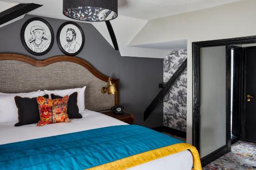 a bedroom with a bed and two clocks on the wall at Hotel Indigo - Stratford Upon Avon by IHG in Stratford-upon-Avon