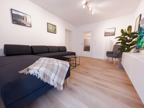 a living room with a black couch and a table at 3-Zimmer Apartment 88 qm bis zu 8 Personen in Winningen