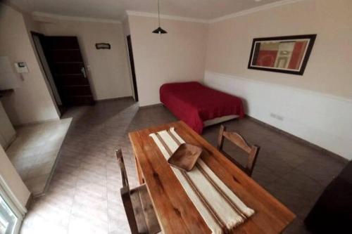Habitación con mesa de madera y cama en Hermoso monoambiente en complejo residencial. en Godoy Cruz