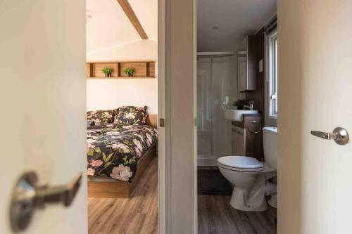 a bathroom with a bed and a toilet and a tub at 6-persoons chalet in Voorthuizen op de Veluwe in Voorthuizen