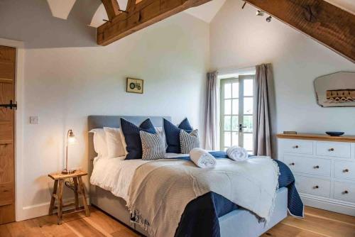 a bedroom with a large bed with blue pillows at Coed farm-hot tub-sleeps 12-near Brecon in Brecon