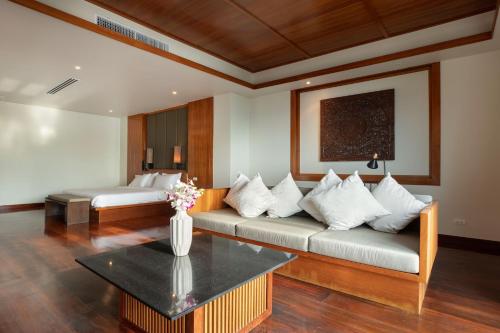 een woonkamer met een bank en een tafel bij Ayara Villa 3 - Unique Gem with Private Pool and Majestic Sea Views in Amphoe Thalang