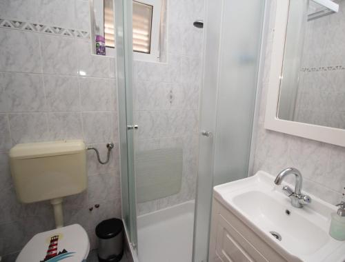 y baño con ducha, aseo y lavamanos. en Apartment Milijana, en Punat