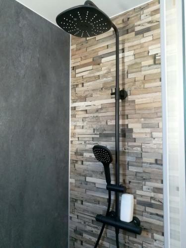 une chaise noire assise devant un mur en pierre dans l'établissement Bienvenue chez vous ! Malo (3mn de la plage), à Dunkerque