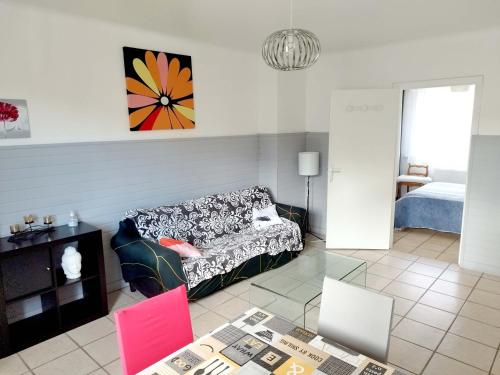 ein Wohnzimmer mit einem Sofa und einem Tisch in der Unterkunft Bienvenue chez vous ! Malo (3mn de la plage) in Dunkerque