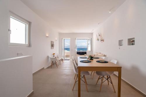 una sala de estar blanca con mesa y sillas en Deluxe Maisonette With Private Jacuzzi, en Molos Parou