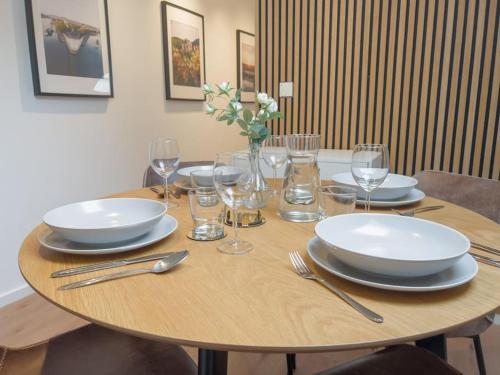 een houten tafel met borden en wijnglazen erop bij 2-Zimmer Apartment 52 qm bis zu 4 Personen in Winningen