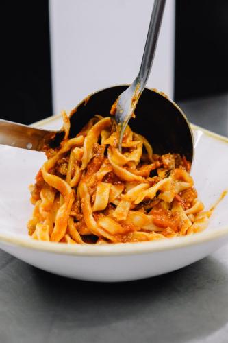 a plate of pasta with a spoon and a fork at AGRITURISMO CA' FENILE in Alzano Lombardo