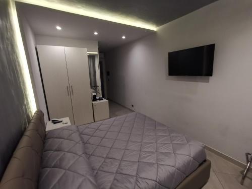 a bedroom with a bed and a flat screen tv at B&B Rossini Luxury in Rende