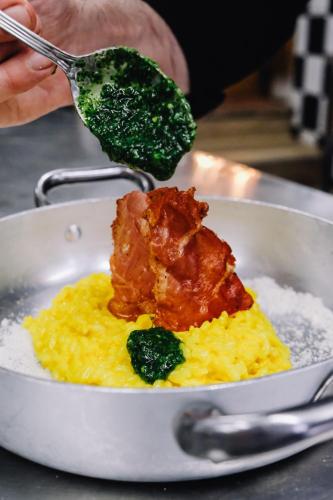 a bowl of food with meat and rice and a spoon at AGRITURISMO CA' FENILE in Alzano Lombardo