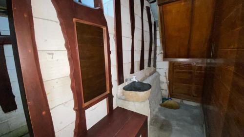 La salle de bains est pourvue d'un lavabo et d'un mur en bois. dans l'établissement Sandhya Giri Beach Resort, à Brono