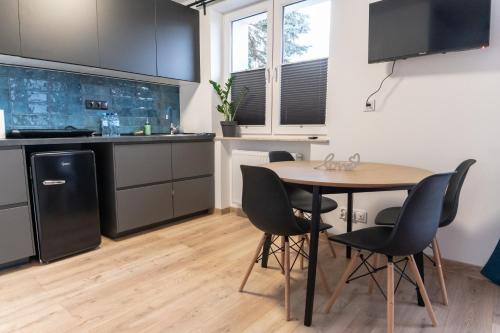 kuchnia ze stołem i krzesłami w pokoju w obiekcie Komfortowe przytulne nowoczesne mieszkanie Radom w Radomiu