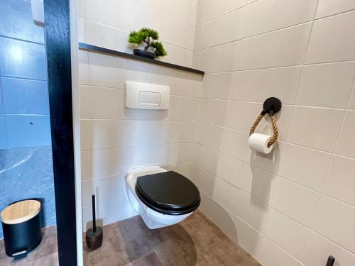 łazienka z toaletą z czarnym fotelem w obiekcie Magnifique studio ~Hipster~ porte du Futuroscope w mieście Chasseneuil-du-Poitou