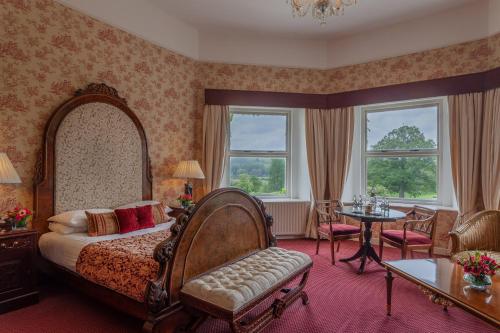 a bedroom with a bed and a table and chairs at Cabra Castle Hotel in Kingscourt