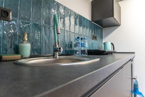 fregadero de cocina con 2 botellas de agua en una encimera en Uroczy, przytulny apartament poddasze en Radom