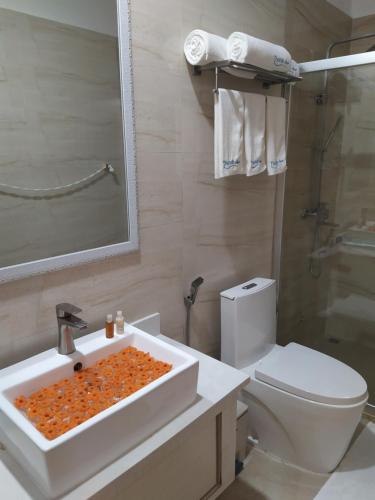 a bathroom with a white sink and a toilet at Thundi Village & Spa in Maalhos