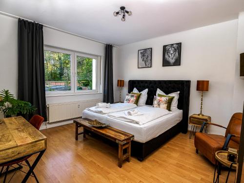 Un dormitorio con una cama y una mesa. en JUNIK Apartments "Am Sternbuschweg" en Duisburg