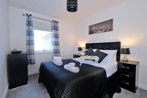a bedroom with a large bed with towels on it at Orange Apartments Beechgrove Gardens in Aberdeen
