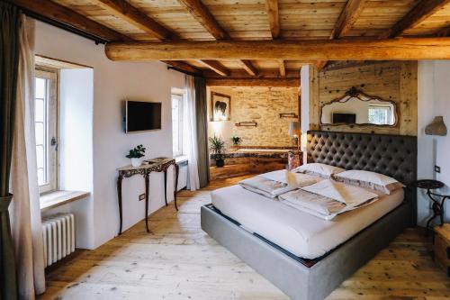a bedroom with a large bed with a wooden ceiling at AGRITURISMO CA' FENILE in Alzano Lombardo
