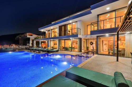 ein großes Haus mit einem Swimmingpool bei Nacht in der Unterkunft Villa Pırlanta, Kalkanvilla in Kalkan