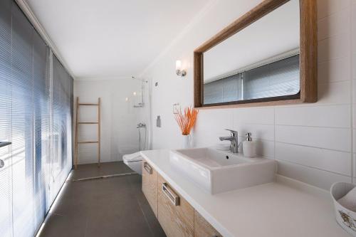 a white bathroom with a sink and a mirror at Villa Pırlanta, Kalkanvilla in Kalkan