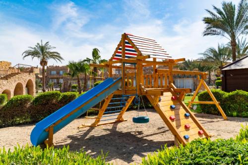 a wooden playground with a slide and a slideintend at Utopia Beach Club in Marsa Alam City