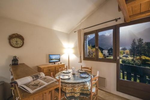 uma sala de jantar com uma mesa e uma janela em Charming apartment in Praz de Chamonix em Chamonix-Mont-Blanc