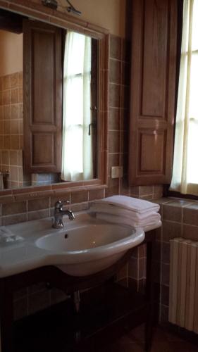 a bathroom with a sink and a mirror and towels at Borgo Di Celle in Città di Castello