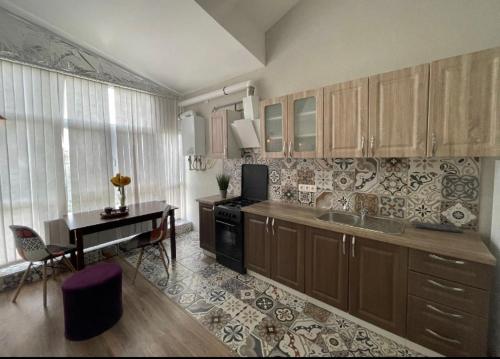 a kitchen with wooden cabinets and a desk and a table at Big and comfortable apartment in Chişinău