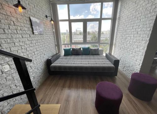 um sofá num quarto com uma grande janela em Big and comfortable apartment em Chisinau