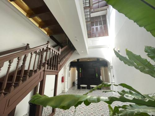 a hallway with wooden stairs and a stair case at The Magazine Boutique Hotel in George Town