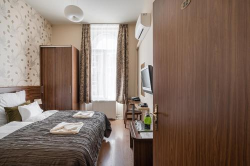 a hotel room with a bed and a television at Elit Boutique Rooms- Best Location by BQA in Budapest