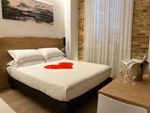 a bedroom with a bed with a red flower on it at Civitaloft Luxury Rooms in Civitanova Marche