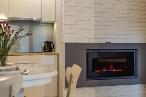 a kitchen with a fireplace with a table and chairs at Pod Tatrami in Zakopane